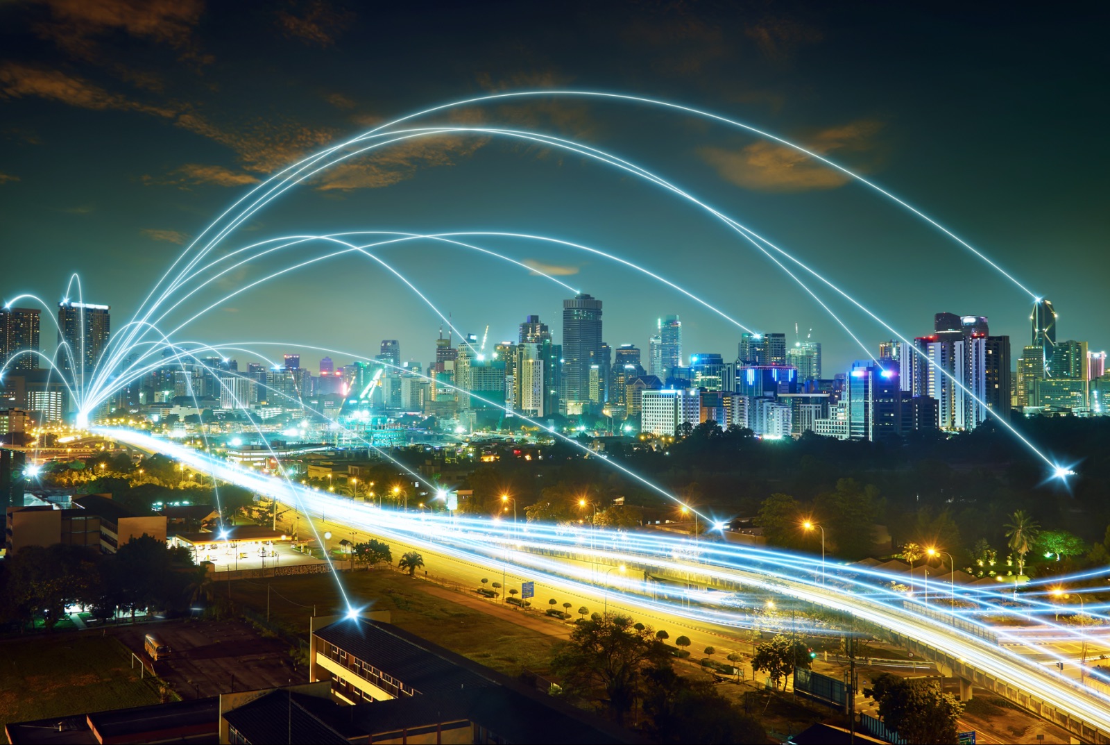 A city at night with light trails arcing between buildings